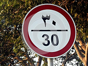 30 KM Speed limit sign, translation of Arabic text is (thirty) kilometers per hour, restriction sign for car drivers