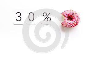 30% off discount - sale concept with bitten donut - on white background top-down copy space