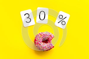 30% off discount - sale concept with bitten donut - on yellow background top-down copy space