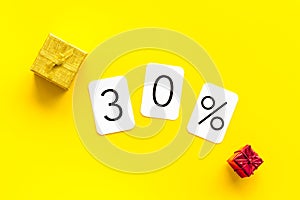 30% off discount - sale concept with present box - on yellow background top-down copy space
