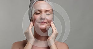 30`s woman takes off a facial sheet mask and looking at camera smiling