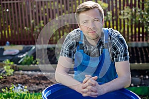 A 30-year-old man resting on ground in a greenhouse