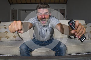 30s or 40s football fan man watching soccer game celebrating his team scoring goal crazy happy screaming cheering his team sitting