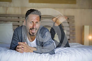 30s happy and handsome man at home in casual shirt and jeans lying on bed relaxed at home smiling confident and happy feeling