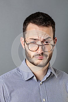 30s man looking sleepy, indifferent and careless with eyeglasses down