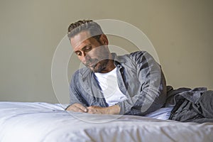 30s to 40s happy and handsome man at home in casual shirt and jeans lying on bed relaxed at home thoughtful and pensive thinking
