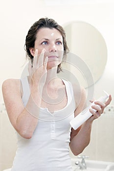 30s Woman Applying Moisturising Cream