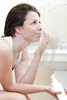 30s Woman Applying Moisturising Cream