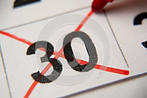 The 30st number in the calendar is crossed out with a red cross in a macro on a white sheet. Calendar for plans, notes