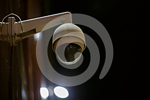 360 degree ball surveillance security camera on building wall at night