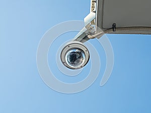 360 Degree fish eye dome CCTV installed under the building balcony against blue sky