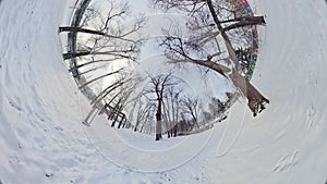 A 360-Degree View of a Snowy Park with a Playground and a Tree in the Center