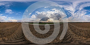 360 hdri panorama view among fields with sunset sky in golden hour in countryside with tractor tires in equirectangular seamless