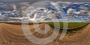 360 hdri panorama view on no traffic gravel road among fields in spring day with beautiful clouds in equirectangular full seamless