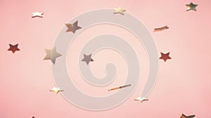 3d animation: Abstract looped background with lots of falling and rotating golden stars on pink-peach background. Holiday and part