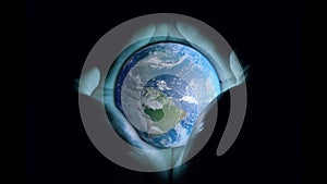3d animation: Men`s hands holding the rotating planet earth with a blue glow on a black background. Seamless loop. The concept of