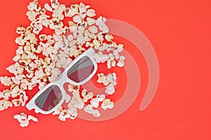 3d glasses and popcorn are isolated on a red background. Flat lay. Copyspace