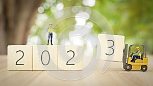 3D illustration. workers are changing year 2023 wooden block on New year and white background