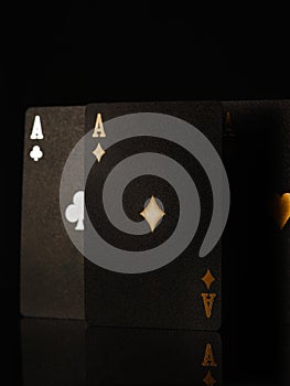 3D image. Black poker cards with gold and silver embossing on a black background. Three aces. Casino, online casino, win, risk,