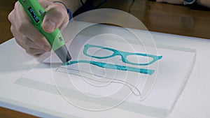 3D pen making real glasses with plastic. Innovative production technology in work.