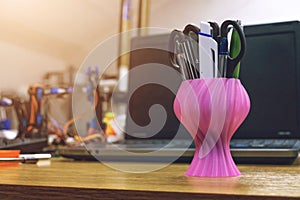 3D printed vase on the background of laptop. Object printed on three dimensional 3d printer