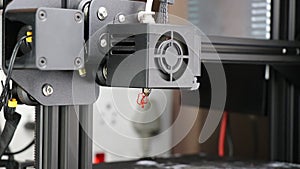 3D printer machine with some fault spilling out filament from its hot end or extruder part with the exhaust fan running