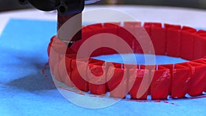 A 3d Printer quickly lays down a new layer on a red ring model