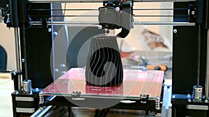 3d printer in work and prints the form of molten plastic close-up.