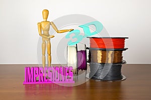 3D printing filament reels with wooden anthropomorphic doll with text in spanish `3d impresiones` on wooden background