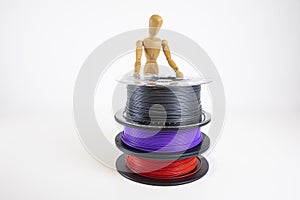 3D printing filament reels with wooden anthropomorphic doll on white background