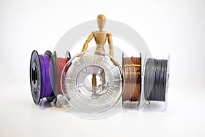 3D printing filament reels with wooden anthropomorphic doll on white background