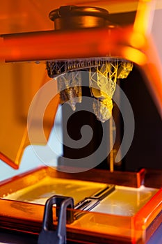 3D printing process. 3D printer for SLA stereolithography printing using photopolymer resin.