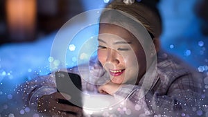 3d render glowing flares and shimmer vfx on young beautiful and happy sweet Asian Korean woman enjoying  with hand phone in bed