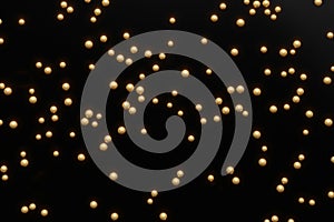 3d render of gold shiny pearles on a black background