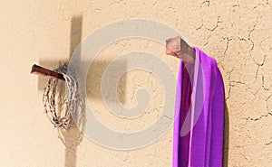 3D rendering of crown of thorns and purple robe hanging on nails