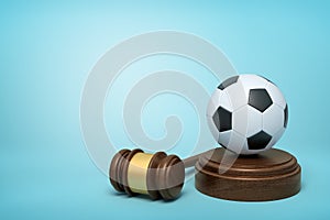 3d rendering of football on sounding block with judge gavel lying beside on light-blue background.