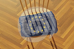 3d rendering of knitted European flag covering a wooden chair which throw shadows in the form of stanchions