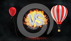 3d rendering of a large flaming word VS stands between a red party balloon and a striped hot air balloon with a basket.