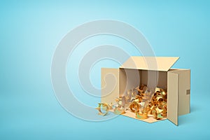 3d rendering of open cardboard box lying sidelong full of golden crowns on light-blue background with much copy space.
