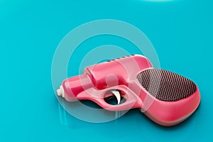 3d rendering a retro pink water gun lay on a pale blue, background