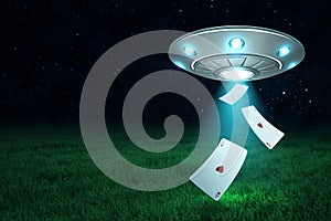 3d rendering of silver metal UFO with playing ace heart cards on dark night sky and green grass background