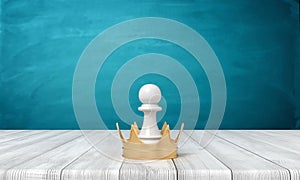 3d rendering of a small white chess pawn standing inside a golden crown on a wooden desk background.
