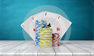 3d rendering of a three stacks of casino chips with four ace cards behind them stand on a wooden table on a blue