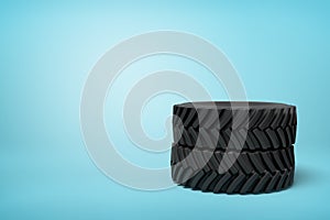 3d rendering of two black wheel tyres stocked on blue background