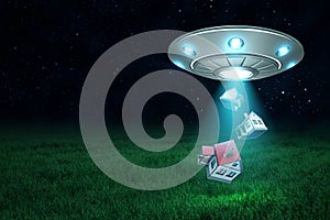 3d rendering of UFO above green field under night sky with three little houses falling down from its open hatch.
