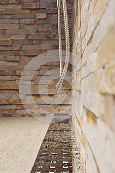 3d rendering of water drops on metal gutter of shower tray with natural stone tiles