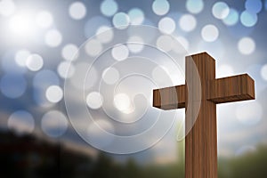 3D rendering of wooden cross on a blue sky with sunlight and bokeh