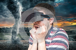 3D simulation concept. Man is wearing virtual reality headset and scared from tornado and storm