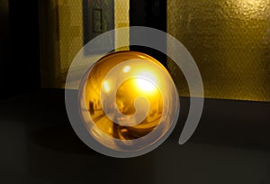 3d sphere on black table background texture with shadow. Crystal shape or realistic glass ball in gold metal. 3D render modern