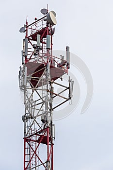 3G, 4G, 5G, wireless and cell phone telecommunication tower close-up on cloudy daylight sky background
